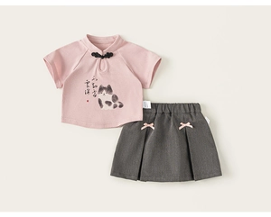 Détail du haut chinois rose avec imprimé chat et jupe plissée grise assortie