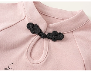 Détail du col en tricot rose avec bouton chinois traditionnel et découpe en goutte