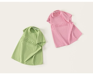 Detail of the 3D embossed Optimism text on pink and green cotton sleeveless kids' vests