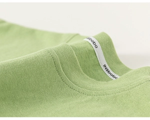 Close-up of ribbed neckline with double-needle stitching on green cotton kids vest