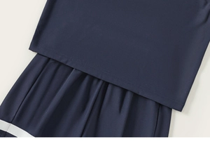 Detail view of navy blue boys' sleeveless jersey and shorts with white trim and neat stitching