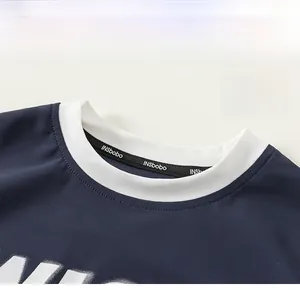 Detail of boys' navy mesh jersey with a white contrast crew neck and woven logo tape