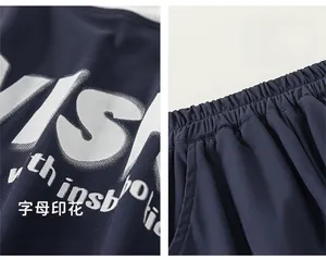Detail of navy blue kids pants showing elastic waistband and white letter print