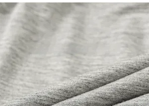 Close-up of grey knit fabric texture showing fine weave and fiber details of the pants
