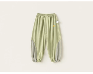 Detail of light green mosquito pants with breathable grey mesh side panels for kids