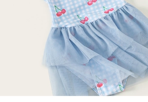Détail d'un maillot de bain fille à carreaux bleu clair, cerises et jupe en tulle