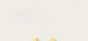 Close-up of yellow knitted rib vest for girls featuring a soft round neck and cute bow detail