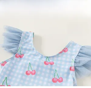 Détail de l'encolure du maillot de bain fille à carreaux bleus et imprimés de cerises
