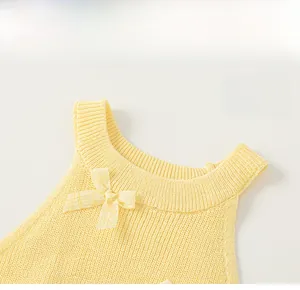 Close-up of yellow knit tank top collar with detailed bow decoration and round neckline