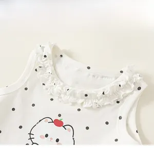 Détail d'un débardeur blanc à pois noirs avec col en dentelle et motif de chat