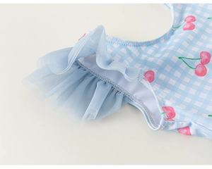 Détail d'un maillot de bain fille vichy bleu clair avec cerises et volants en tulle