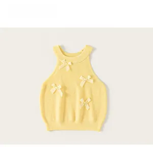Detailed view of yellow knitted girls' tank top with textured vertical ribbing and bows