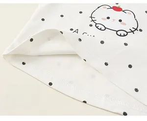 Détail de couture à double aiguille sur le débardeur blanc à pois pour fille
