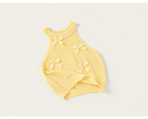 Detailed view of yellow sleeveless knit top with ribbon bows and ribbed texture