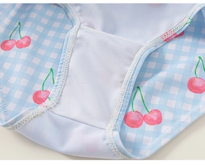 Détail du maillot de bain fille avec motif à carreaux bleus, imprimé cerise et doublure mesh