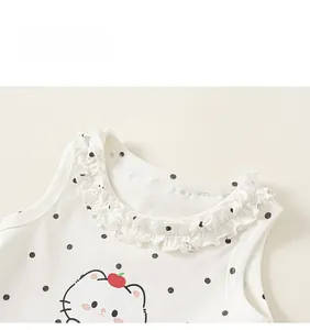 Détail d'un débardeur blanc pour fille avec col à volants et motifs à pois noirs