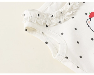 Détail du tissu en coton doux à pois noirs et finitions de bords à volants soignés