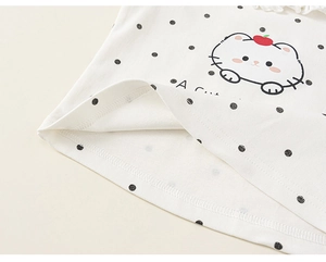 Détail du tissu en coton blanc à pois noirs avec imprimé chat pour haut de fille