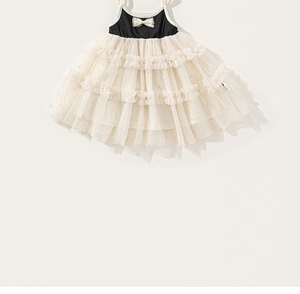 Detail of girls' princess dress featuring a black bodice with white bow and gold glitter mesh