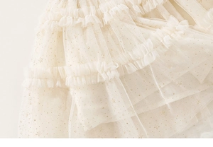 Detailed macro view of multi-layered tulle fabric with golden glitter on a girls party dress