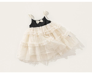 Detail of girls' summer tutu dress featuring a satin bow and layered mesh with gold sequins