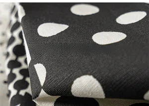 Macro detail of breathable black and white polka dot fabric for lightweight kids' pants