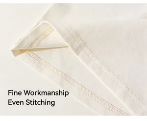 Close-up of precise double-needle stitching on cream cotton kids t-shirt hem