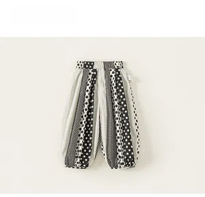 Detail of girls' polka dot harem pants featuring elastic waistband and cuffed ankles