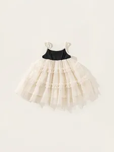 Elegant girl's tutu dress with black bodice and cream tiered mesh skirt with golden glitter