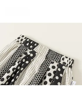 Detailed macro view of elastic waistband and black and white polka dot pattern on kids' pants