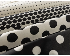 Detailed macro view of black and white polka dot patterns on soft summer cotton fabric