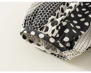 Detail of loose-fit summer pants showing polka dot pattern and elastic cuff texture