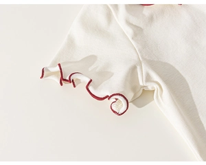 Close-up of white ribbed cotton t-shirt with red lettuce edge stitch detail on the sleeve