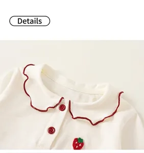 Detail of Peter Pan collar with red scalloped trim and cute strawberry embroidery