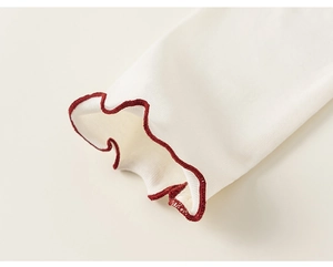 Close-up of white ribbed knit sleeve with red ruffled lettuce edge trim for girls
