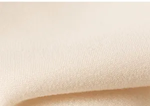 Macro view of soft cream knit fabric texture on a sweet short-sleeve children shirt
