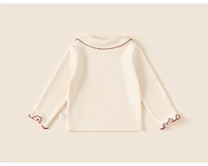 Detail of sweet long sleeve kids shirt with red wavy trim on collar and cuffs