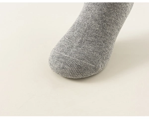 Detailed macro view of gray knitted cotton kids sock showing high quality toe seam texture