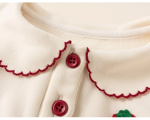 Detail of girls' cream long sleeve top with Peter Pan collar and red wavy embroidery