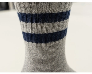 Macro view showing ribbed texture and navy stripes on gray cotton knit socks
