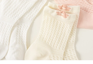Détail de chaussettes en coton respirant avec bordure en dentelle fleurie rose et blanc