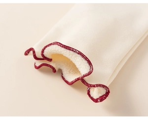 Close-up of girl's top with cream ruffle edges and thick warm fleece lining detail