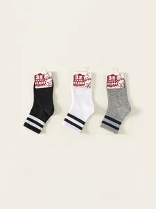 Three pairs of striped kids crew socks in black white and gray with sporty double stripes