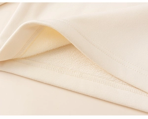 Detailed close-up of warm fleece lining and sturdy double-stitch seam of kids cream top