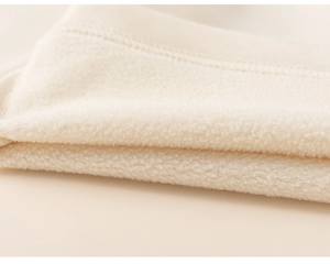 Macro view of soft off-white fleece lining fabric with durable double-stitch detail