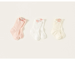 Détail du tricot en maille respirante des chaussettes en coton pour bébé en trois couleurs