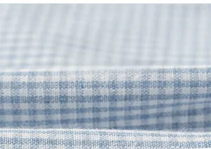 Macro shot of blue and white checkered fabric texture with soft cotton weave details