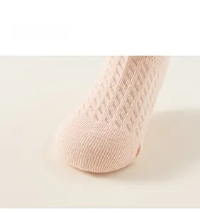 Détails de la maille respirante et de la pointe tricotée sur les chaussettes roses bébé