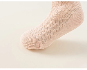 Gros plan de chaussettes en maille rose pour filles avec motif ajouré respirant