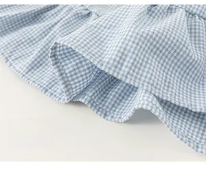 Detailed macro view of the light blue checkered fabric with ruffled hem on the dress